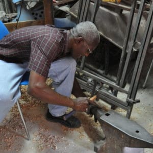A professor demonstrating techniques in metalworking